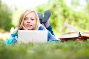 girl on grass with laptop